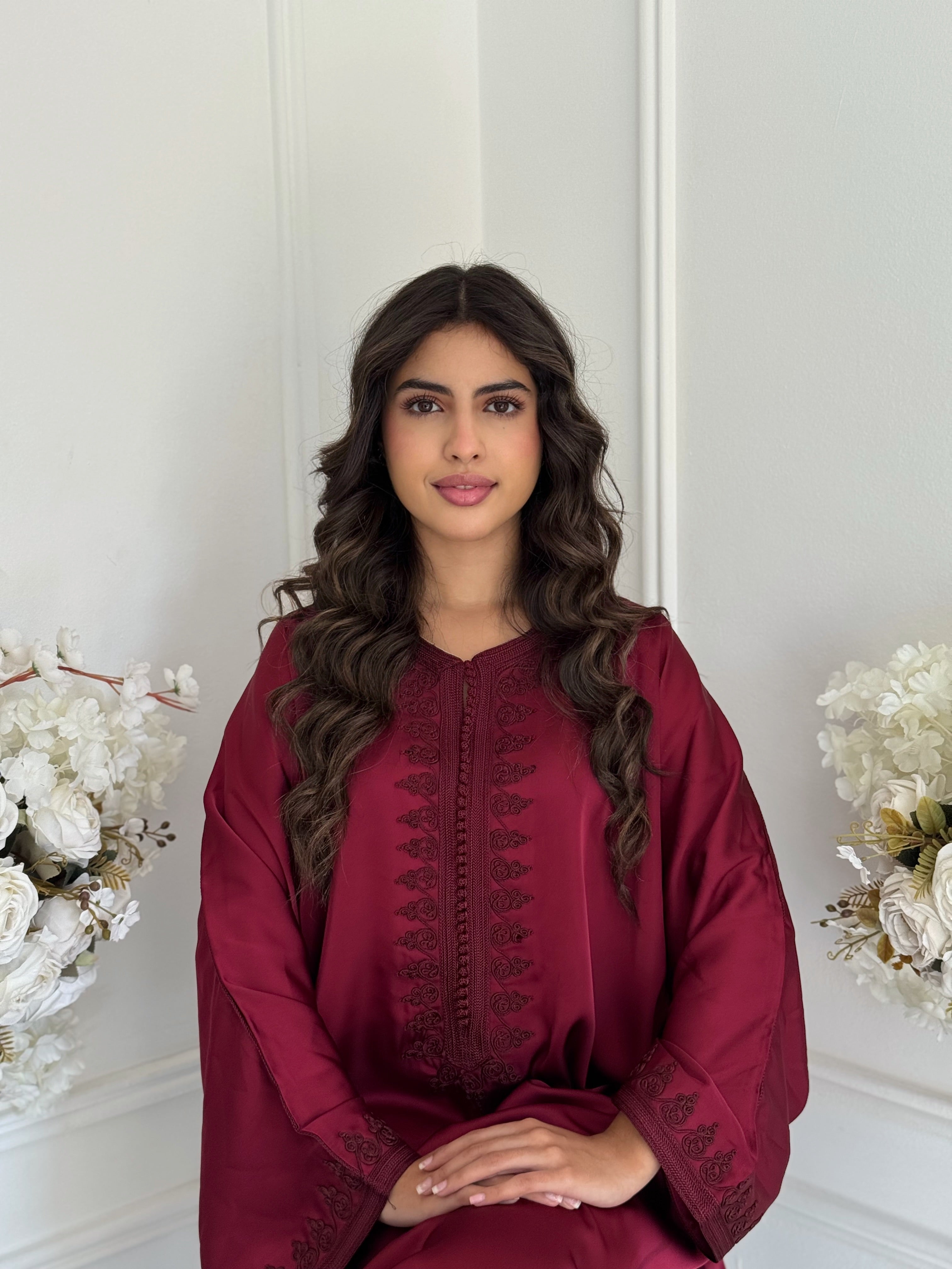 “Model wearing Gandoura Maryam — elegant Moroccan gandoura in deep burgundy drap de soie with handmade embroidery.”