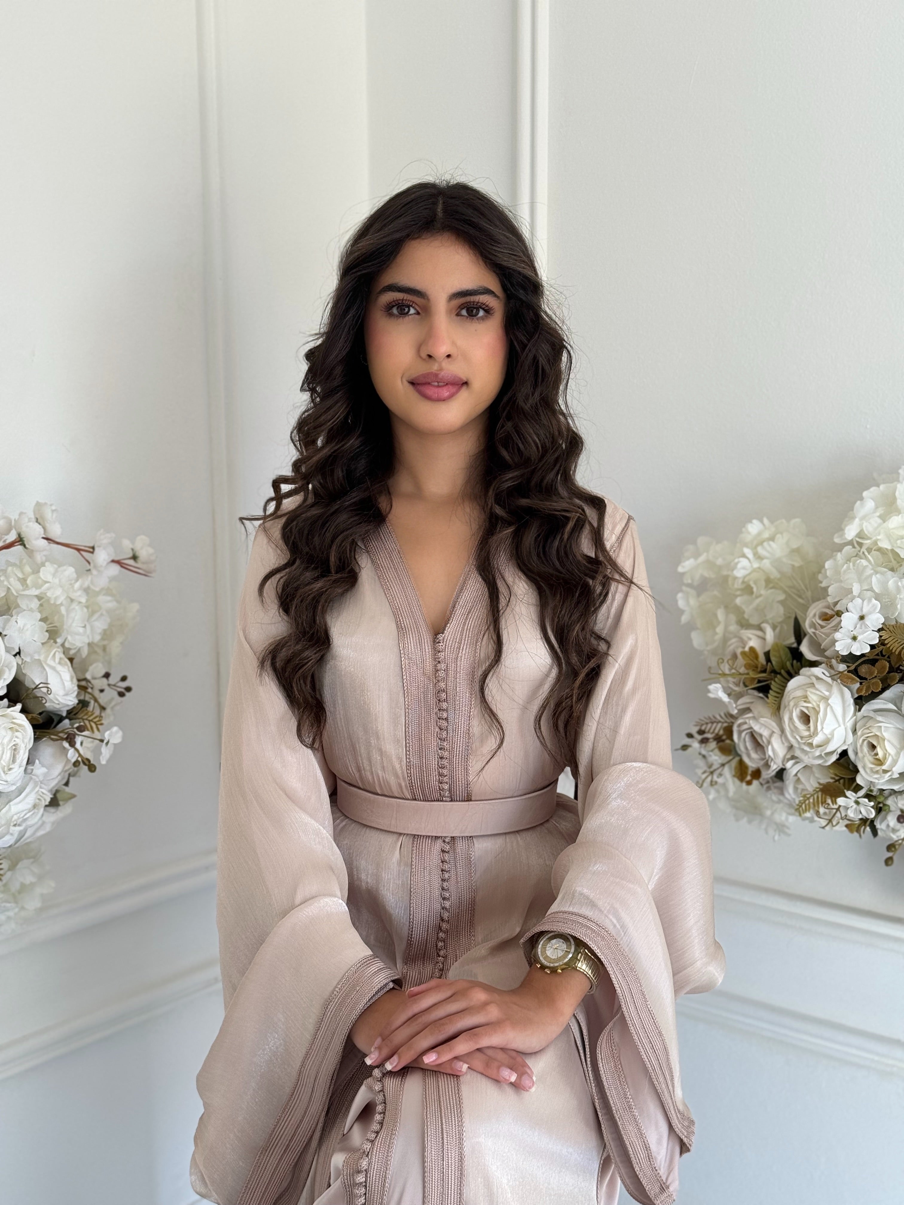 Model wearing the white Takchita Nisae Moroccan dress with embroidered satin fabric.