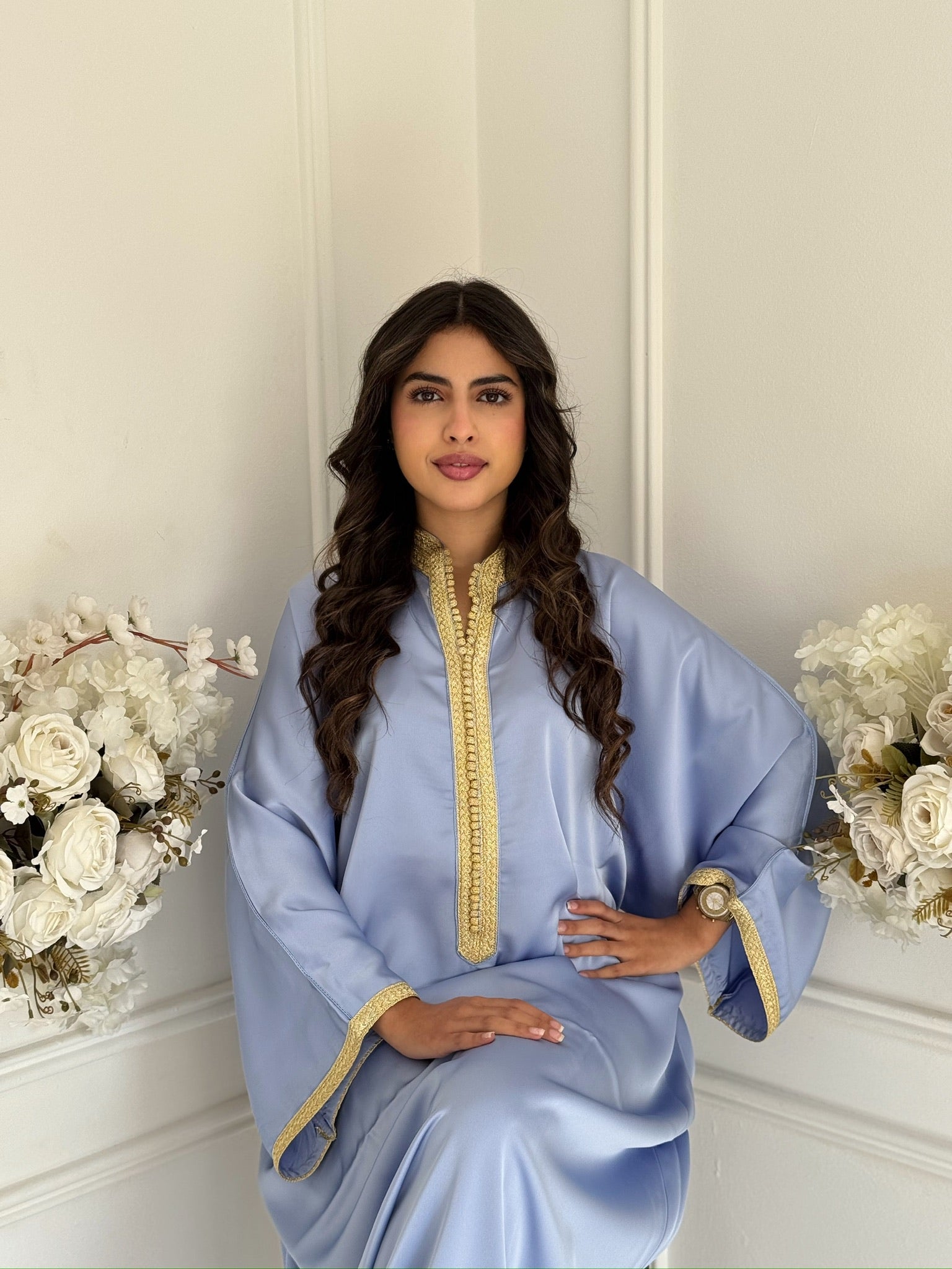 Model wearing the light blue Gandoura Abida Moroccan dress with gold embroidery.”