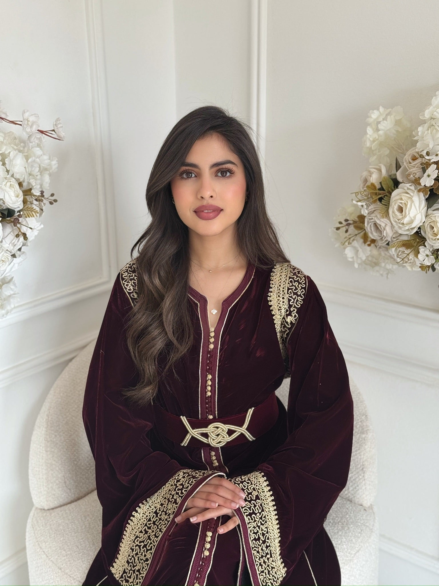 Model wearing Caftan Lina – burgundy velvet Moroccan caftan with gold embroidery