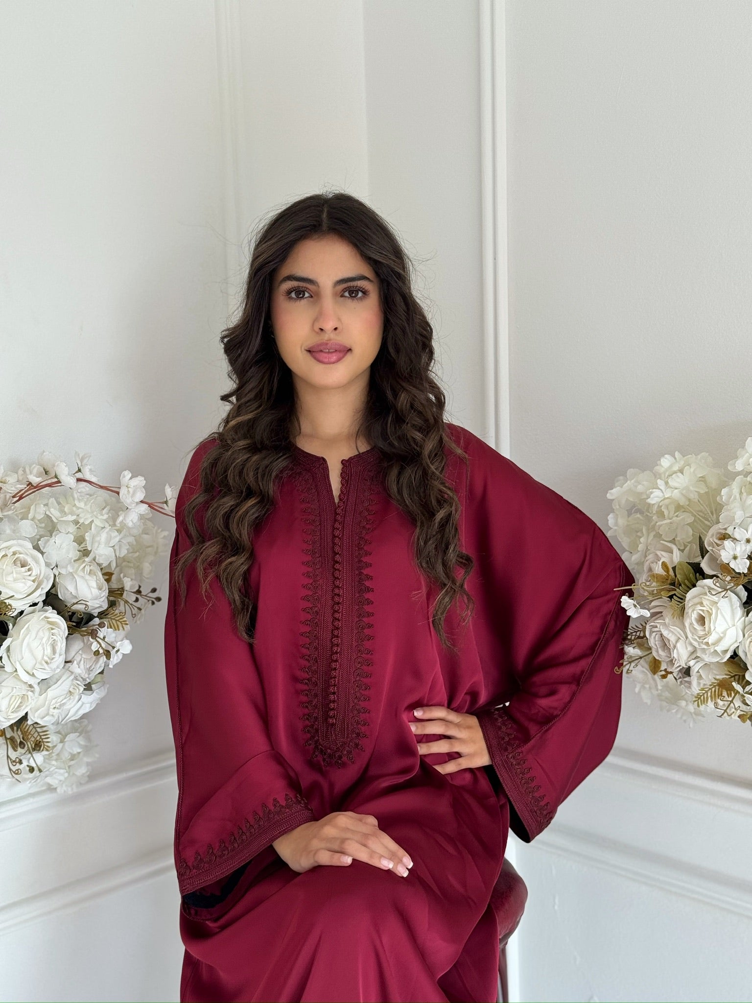 Model wearing the deep burgundy Gandoura Miral Moroccan dress made from drap de soie.”
