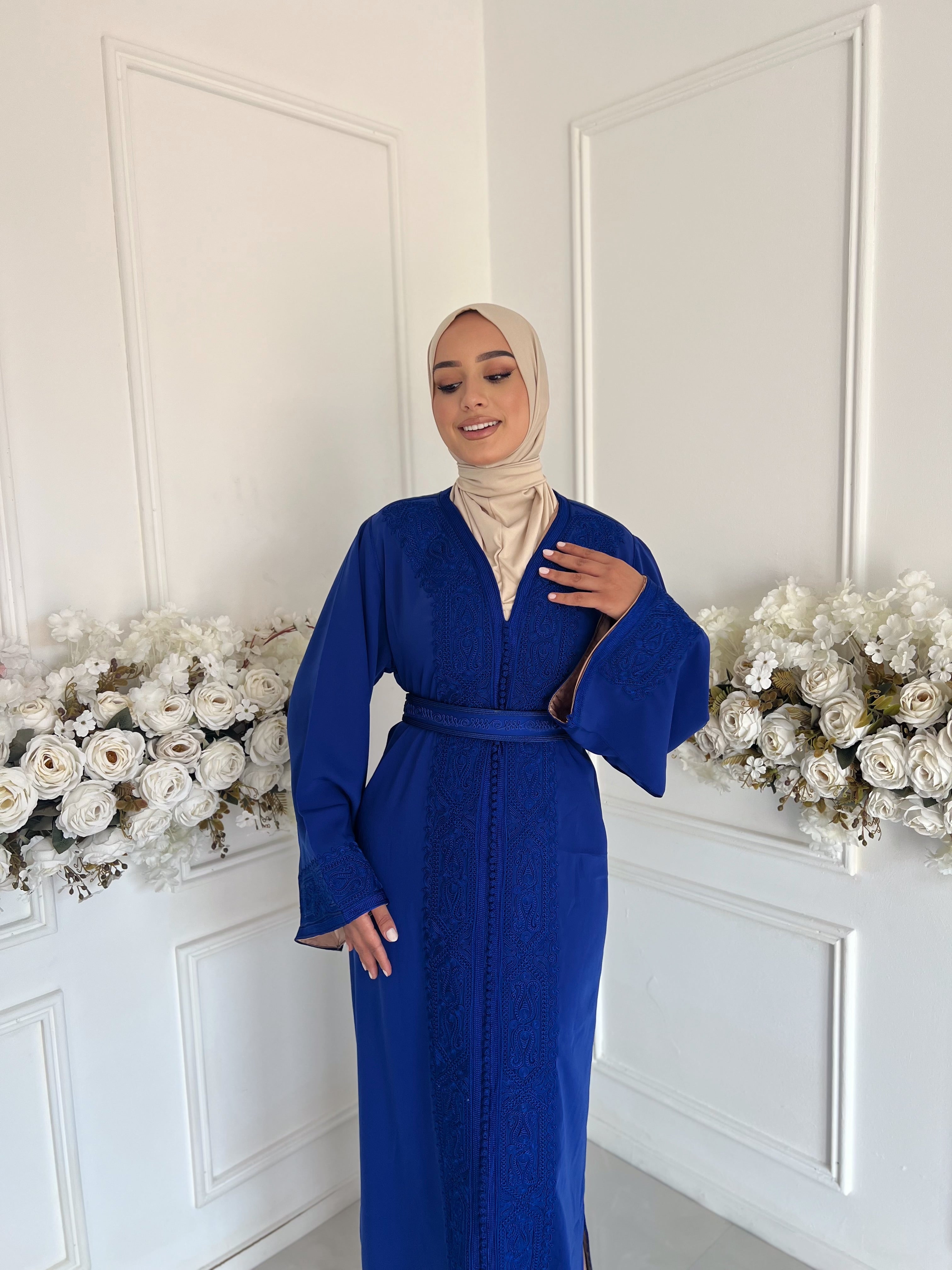 Model wearing Caftan Mayssa – royal blue Moroccan crepe caftan with belt.
